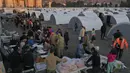 Orang-orang yang kehilangan rumah akibat gempa dahsyat, berbaris untuk menerima makanan di kamp darurat, di kota Iskenderun, Turki selatan, Selasa, 14 Februari 2023. Ribuan orang kehilangan tempat tinggal akibat gempa bumi dahsyat yang melanda Turki dan Suriah seminggu yang lalu. (AP Photo/Hussein Malla)