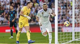 Pemain Real Madrid, Karim Benzema, melakukan selebrasi setelah mencetak gol ke gawang Almeria pada laga Liga Spanyol di Stadion Santiago Bernabeu, Minggu (30/4/2023). Tiga dari empat gol Real Madrid disumbangkan Benzema. (AP Photo/Pablo Garcia)