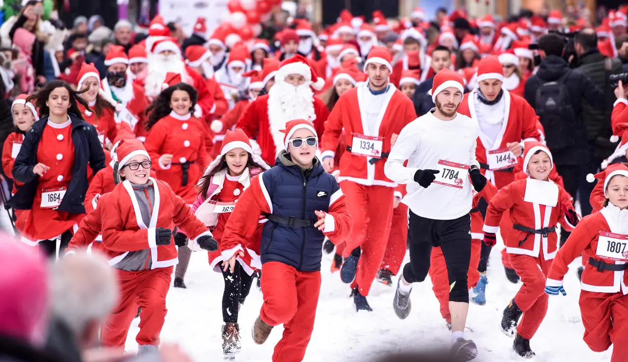 Orang-orang berpakaian seperti Sinterklas mengambil bagian dalam Santa Claus Run di Pristina, Kosovo, Minggu (16/12). Ratusan pelari berpartisipasi dalam lomba lari amal untuk menggalang dana bagi keluarga yang membutuhkan di Kosovo. (Armend NIMANI/AFP)