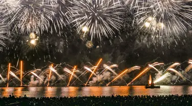 Orang-orang berkumpul untuk menonton kembang api pada Hari Bastille di sebuah pantai di Cannes, Prancis, Rabu (14/7/2021). Prancis merayakan Hari Bastille dengan ribuan tentara berbaris dalam parade Paris, setelah acara tahun lalu dikurangi karena ketakutan akan COVID-19. (AP Photo/Vadim Ghirda)