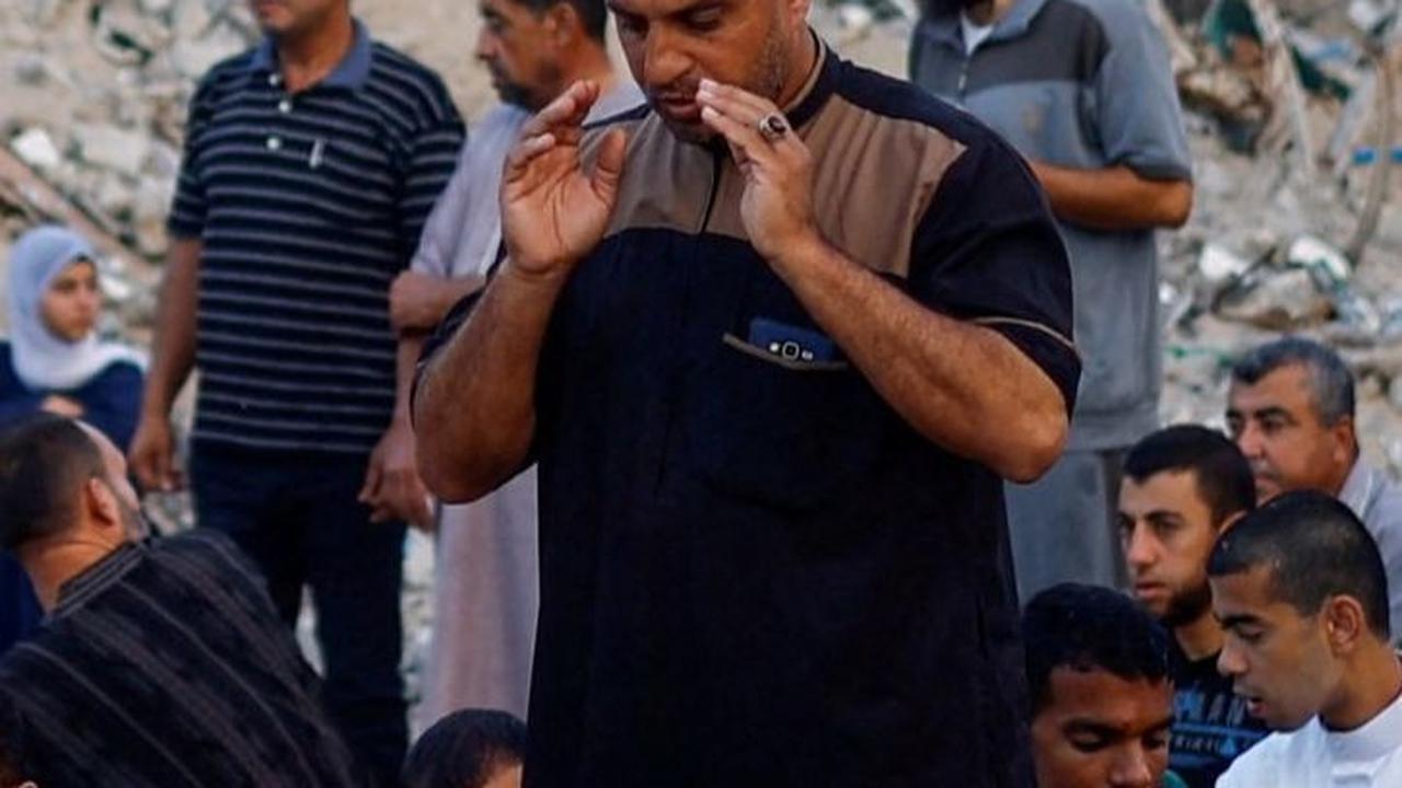 Di sana mereka berdoa untuk menemukan kedamaian dan kekuatan saat melaksanakan salat Iduladha yang diadakan apa adanya di tengah kehancuran. Foto: REUTERS / Mohammed Salem<br>