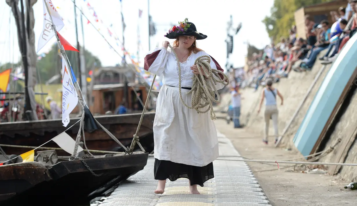 Seorang mengenakan kostum menarik perahu untuk bersandar saat Festival Loire di Orleans, Prancis (24/9). Dalam festival ini peserta mengenakan pakaian bergaya abad pertengahan. (AFP Photo/Guillaume Souvant)