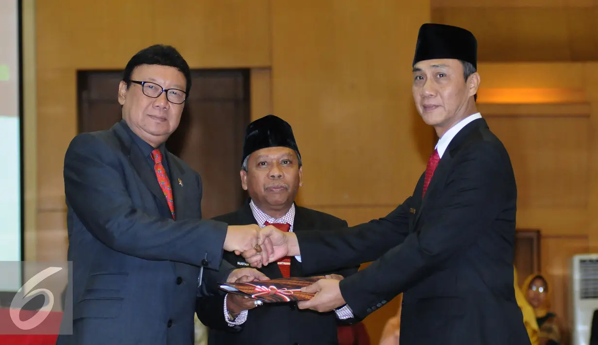 Mendagri Tjahjo Kumolo (kiri) menyerahkan nota pengantar tugas dari Gubernur Bangka Belitung Rustam Effendi kepada Yuswandi A Tumenggung (kanan) di Kemendagri, Jakarta, Kamis (27/10). (Liputan6.com/Helmi Fithriansyah)