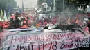 Buruh membakar keranda mayat sebagai simbol kekecewaan terhadap kebijakan pemerintah di Jalan Medan Merdeka Barat, Jakarta, Senin (1/5). (Liputan6.com/Yoppy Renato)