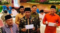 Presiden Joko Widodo (Jokowi) dan Wakil Presiden Jusuf Kalla (JK) membayar zakat penghasilan sebesar Rp 50 juta melalui Badan Amil Zakat Nasional (BAZNAS) di Istana Negara, Jakarta, Senin (28/5/2018).