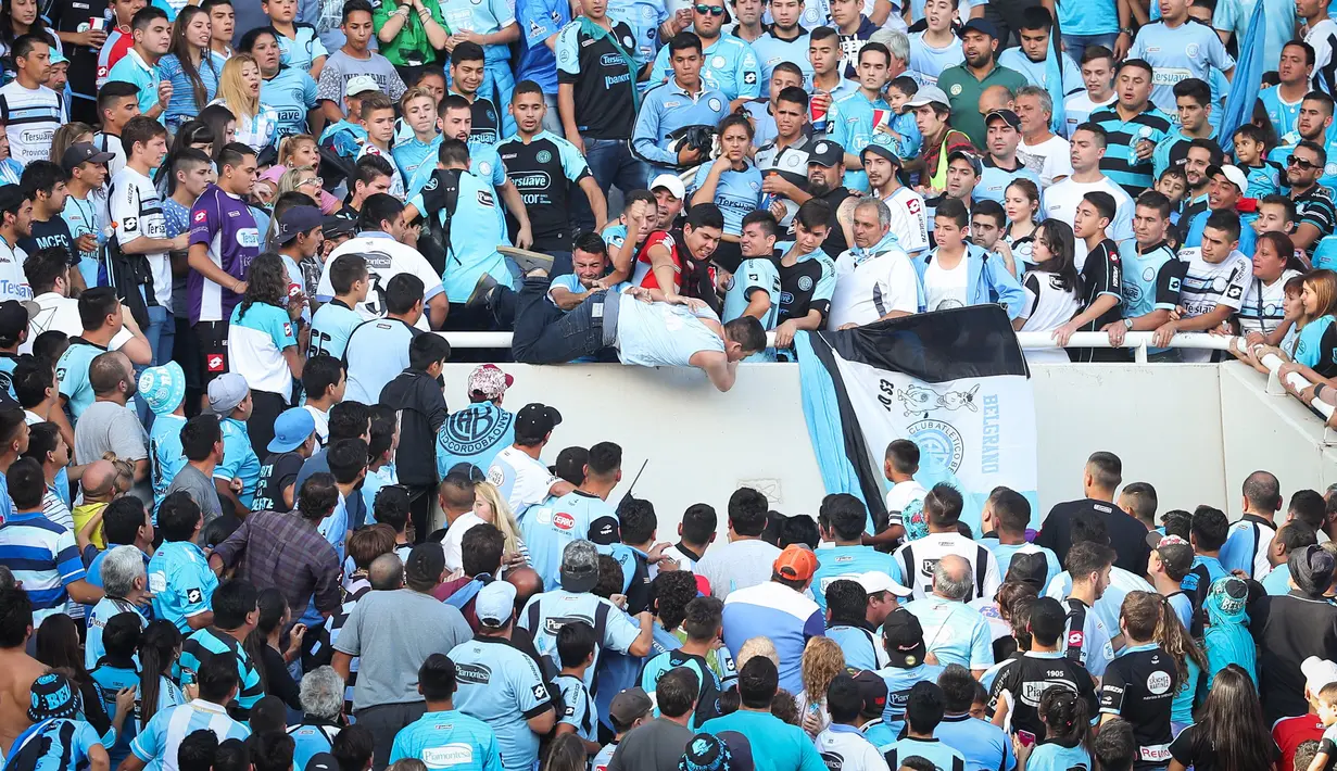 Seorang fans dari tim Belgrano, Emanuel Balbo didorong oleh penonton lain dari tribun Stadion Belgrano, Kota Cordoba di Argentina, 15 April 2017. Emanuel langsung tidak sadarkan diri karena mendarat menggunakan kepala. (NICOLAS AGUILERA/AFP)