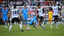 Pemain depan Atletico Madrid, Angel Correa (tengah) ditekel oleh bek Valencia, Hugo Guillamon (kedua kanan) selama pertandingan lanjutan La Liga Spanyol di stadion Mestalla di Valencia (8/11/2021). Valencia bermain imbang atas Atletico Madrid 3-3. (AFP/Jose Jordan)