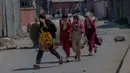 Gadis-gadis Kashmir berlari selama bentrokan di Srinagar, Kashmir yang dikuasai India, (1/4). Pengunjuk rasa memprotes menyusul tewasnya delapan pemberontak dalam bentrokan dengan pasukan pemerintah. (AP Photo / Dar Yasin)