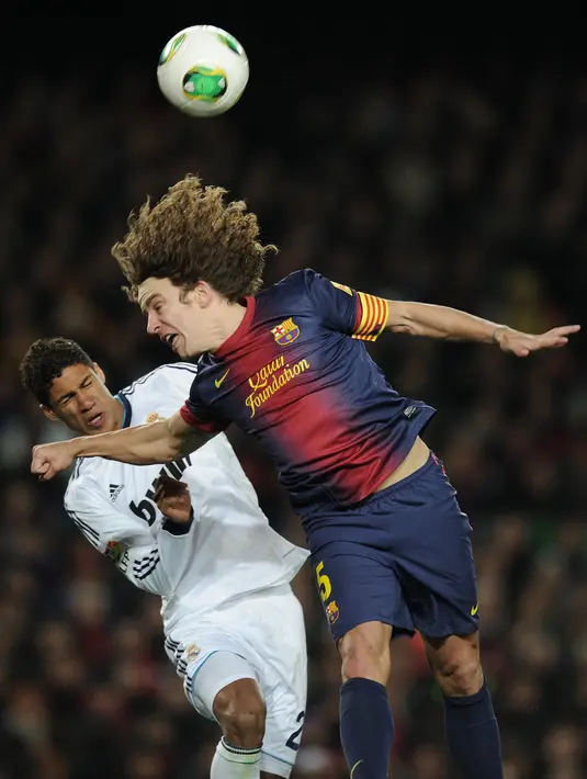 <p>Bek Real Madrid, Raphael Varane berebut bola dengan bek Spanyol, Carles Puyol selama pertandingan leg kedua semifinal Piala Spanyol di stadion Camp Nou di Barcelona pada 26 Februari 2013. Pelatih timnas Prancis Didier Deschamps mengatakan dia menghormati keputusan yang diambil pemain. (AFP/LLUIS GENE)</p>