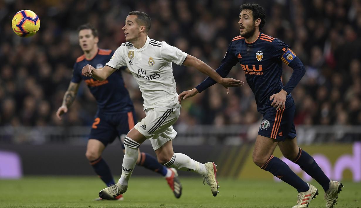 Striker Real Madrid, Lucas Vazquez, beradu cepat dengan gelandang valencia, Daniel Parejo, pada laga La Liga di Stadion Santiago Bernabeu, Madrid, Sabtu (1/12). Madrid menang 2-0 atas Valencia. (AFP/Oscar Del Pozo)