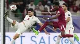 Pemain Iran, Saeid Ezatolahi (kiri) menendang bola dibayangi pemain Qatar, Yusuf Abdurisag pada laga semifinal Piala Asia 2023 di Al Thumama Stadium, Doha, Qatar, Rabu (07/02/2024). (AP Photo/Thanassis Stavrakis)