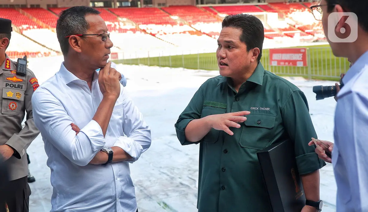 Ketua Umum PSSI merangkap Ketua LOC Erick Thohir berbincang dengan Penjabat (Pj) Gubernur DKI Jakarta, Heru Budi Hartono saat melakukan inspeksi di Stadion Utama Gelora Bung Karno (SUGBK), Senayan, Jakarta, Senin (13/3/2023). Seperti diketahui, Stadion Utama Gelora Bung Karno merupakan satu dari enam lokasi yang ditunjuk menjadi venue penyelenggaraan Piala Dunia U-20 2023. (Liputan6.com/Angga Yuniar)