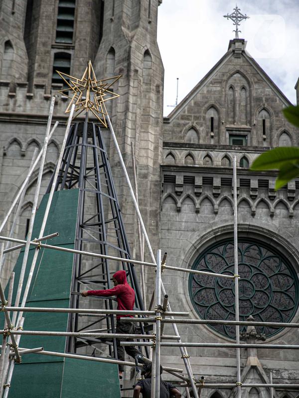 Pekerja menyelesaikan pembuatan pohon Natal di Gereja Katedral, Jakarta pada Rabu (16/12/2020). Gereja Katedral Jakarta membuat pohon natal dengan tinggi lebih dari 10 meter dalam rangka menyambut perayaan Natal. (Liputan6.com/Faizal Fanani)
