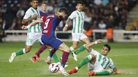 Pemain Barcelona, Robert Lewandowski, berusaha melewati pemain Real Betis pada laga Liga Spanyol di Estadi Olimpic Lluis Companys, Minggu (17/9/2023). Barca menang dengan skor 5-0. (AP Photo/Joan Monfort)