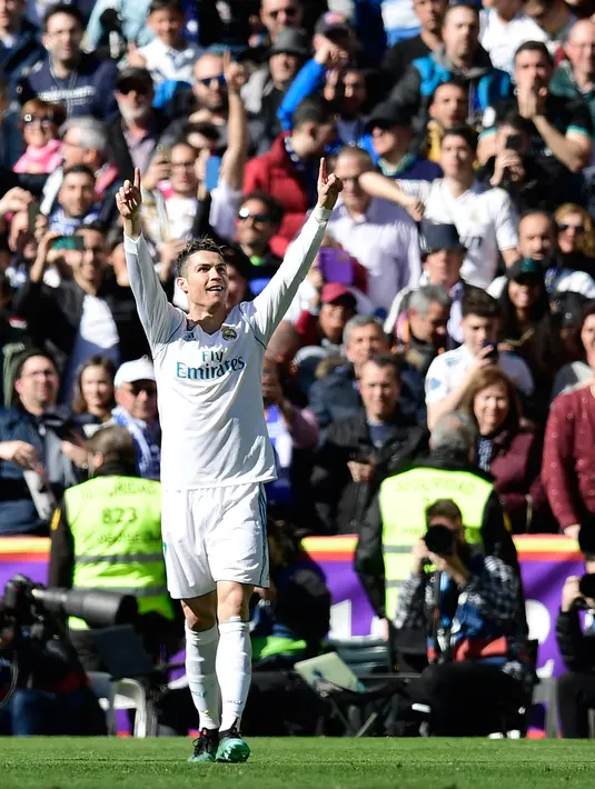 Stiker Real Madrid Cristiano Ronaldo melakukan selebrasi usai membobol gawang Atletico Madrid dalam pertandingan La Liga Spanyol di stadion Santiago Bernabeu di Madrid (8/4). Ronaldo mencetak satu gol untuk Real Madrid. (AFP/Javier Soriano)