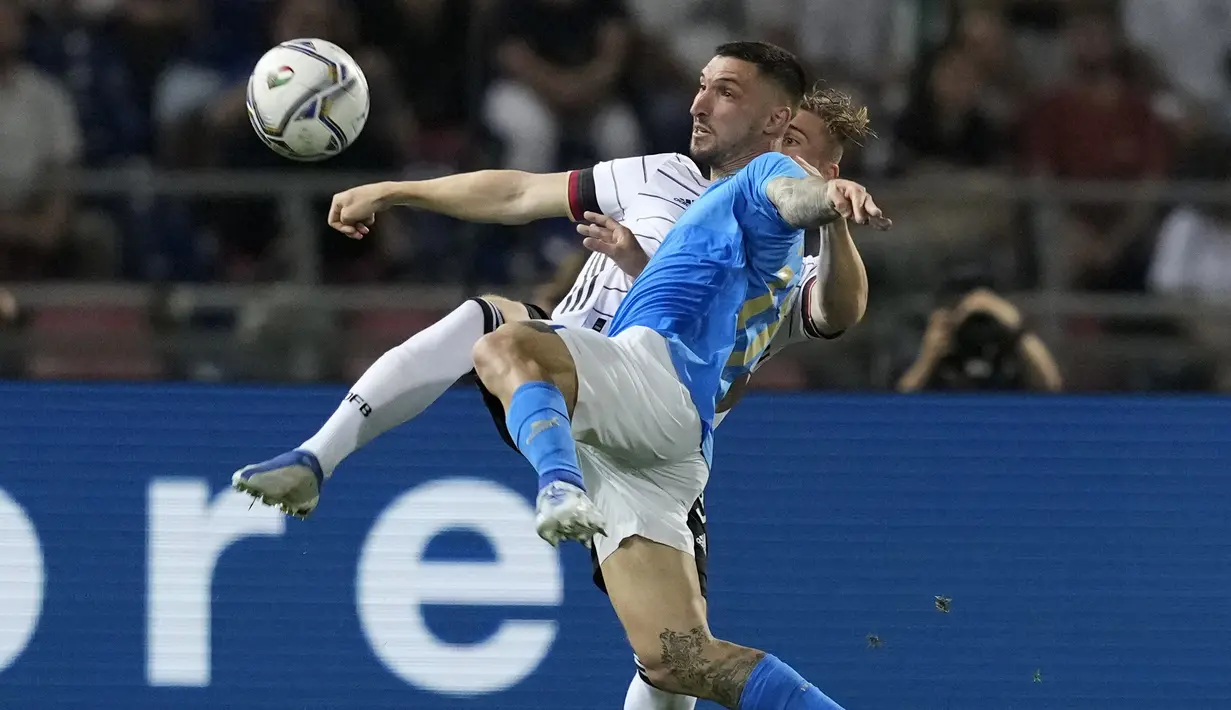 Penyerang timnas Italia Matteo Politano berebut bola dengan penyerang Jerman Timo Werner pada matchday pertama UEFA Nations League A Grup 3 di Renato Dall'Ara, Minggu (6/5/2022) dini hari WIB. Jerman bermain imbang melawan Italia dengan skor 1-1. (AP Photo/Antonio Calanni)