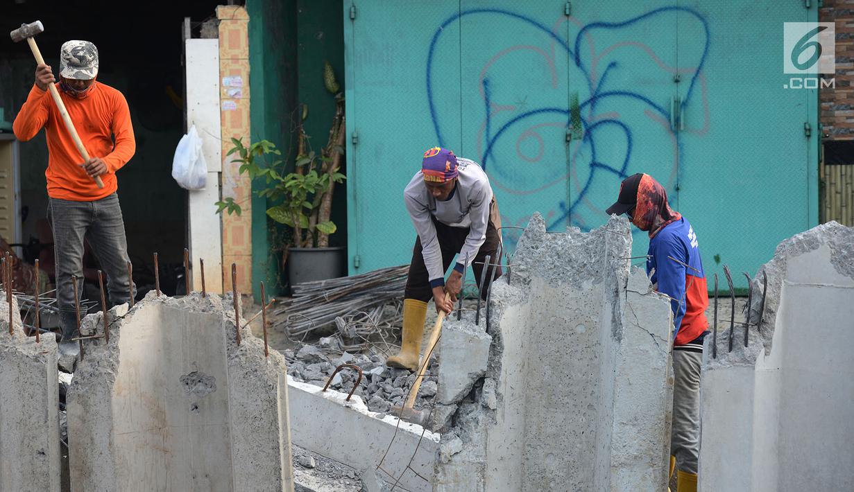 Pekerja membongar bangunan saat memasang turap di Kali Item, Jakarta, Rabu (2/1). Turap sepanjang 1.900 meter pada sisi kanan dan kiri kali untuk mengantisipasi genangan dan banjir di kawasan tersebut pada musim hujan. (Merdeka.com/Imam Buhori)