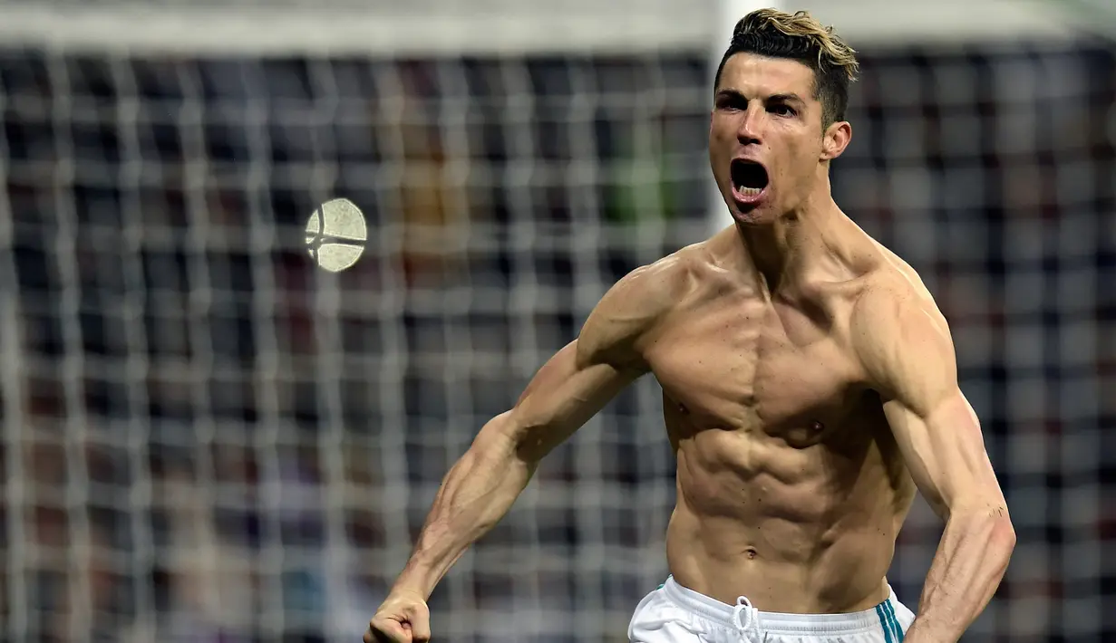 Striker Real Madrid Cristiano Ronaldo menunjukkan ototnya saat merayakan gol usai membobol gawang Juventus lewat tendangan penalti dalam petandingan Liga Champions di stadion Santiago Bernabeu, Madrid (11/4). (AFP Photo/Oscar Del Pozo)