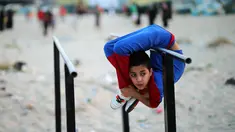 Mohammed al Sheikh menunjukkan kemampuannya di sebuah pantai di Kota Gaza, Palestina, Kamis (2/6). Dengan tinggi 1,6 meter dan berat 29 kg, Mohammed mampu menekukan tubuhnya dengan posisi yang menurut kita mustahil untuk dilakukan (REUTERS/Mohammed Salem)
