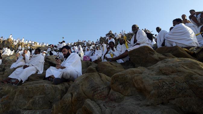 Jemaah haji dari seluruh dunia mengunjungi Jabal Rahmah menjelang Wukuf di Padang Arafah, Makkah, Arab Saudi, Sabtu (10/8/2019). Pada saat Wukuf para jamaah dianjurkan berdiam diri, berdoa dan banyak membaca ayat suci Al Quran. (FETHI BELAID / AFP)