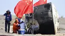 Para pekerja membuka kapsul pesawat ruang angkasa berawak Shenzhou-12 setelah berhasil mendarat di lokasi pendaratan Dongfeng di Daerah Otonomi Mongolia Dalam, China, 17 September 2021. Trio astronot China kembali ke Bumi setelah 90 hari tinggal di Stasiun Luar Angkasa. (Ren Junchuan/Xinhua via AP)