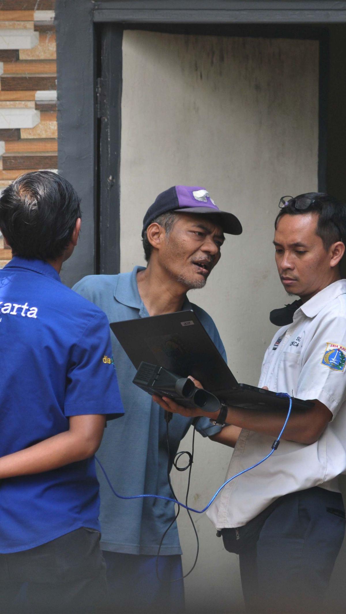 Petugas Dukcapil DKI melakukan perekaman e-KTP terhadap Suradi, warga penyandang disabilitas gangguan jiwa (ODGJ), di Jalan Waru RT004/02, Cilangkap, Jakarta Timur, Rabu (15/5/2024).&nbsp;Foto: Merdeka.com/Imam Buhori