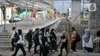 Calon penumpang kereta listrik Commuterline (KRL) saat melintas di dekat proyek pembangunan Stasiun Manggarai, Jakarta, Rabu (22/2/2023). Kepala Balai Teknik Perkeretaapian Wilayah Jakarta-Banten Rode Paulus mengungkapkan, pembangunan Stasiun Manggarai sisi timur tahap II ditargetkan akan selesai 2023. (merdeka.com/Iqbal S Nugroho)