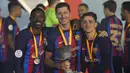 Para pemain Barcelona, Ousmane Dembele, Robert Lewandowski dan Gavi berpose dengan trofi usai menjuarai final Piala Super Spanyol di Stadion King Fahd, di Riyadh, Arab Saudi, Senin (16/1/2023). Trofi ini sekaligus menjadi trofi pertama Xavi Hernandez sebagai juru taktik Barcelona. (AP Photo/Hussein Malla)