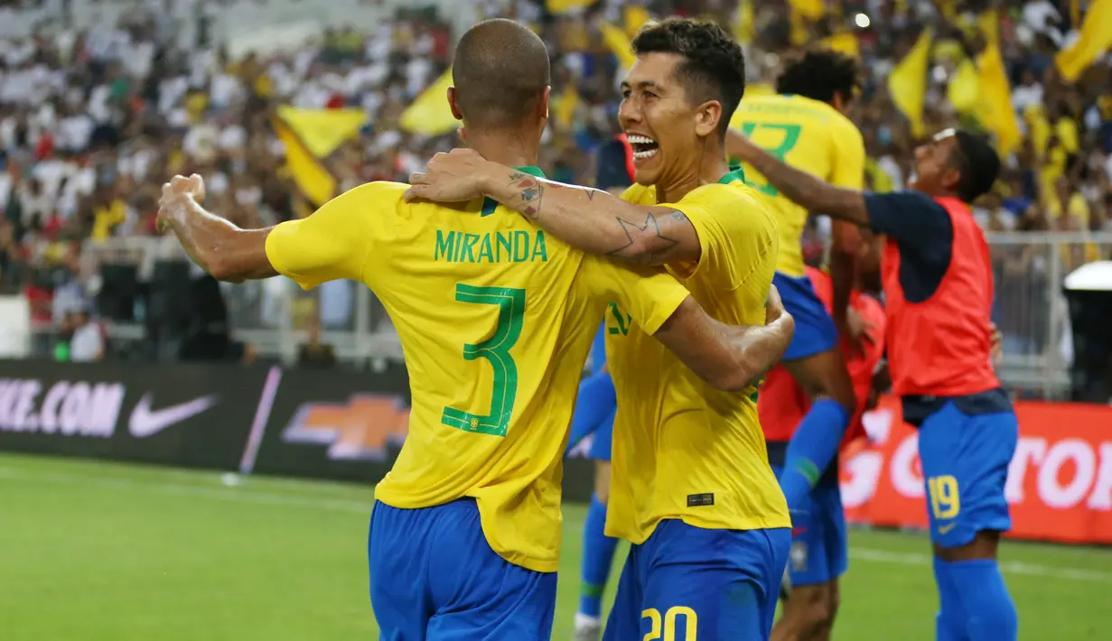 Bek Brasil, Miranda, melakukan selebrasi bersama Roberto Firmino usai membobol gawang Argentina, pada laga persahabatan di Stadion King Abdullah, Jeddah, Selasa (16/10/2018). Brasil menang 1-0 atas Argentina. (AFP/STR)
