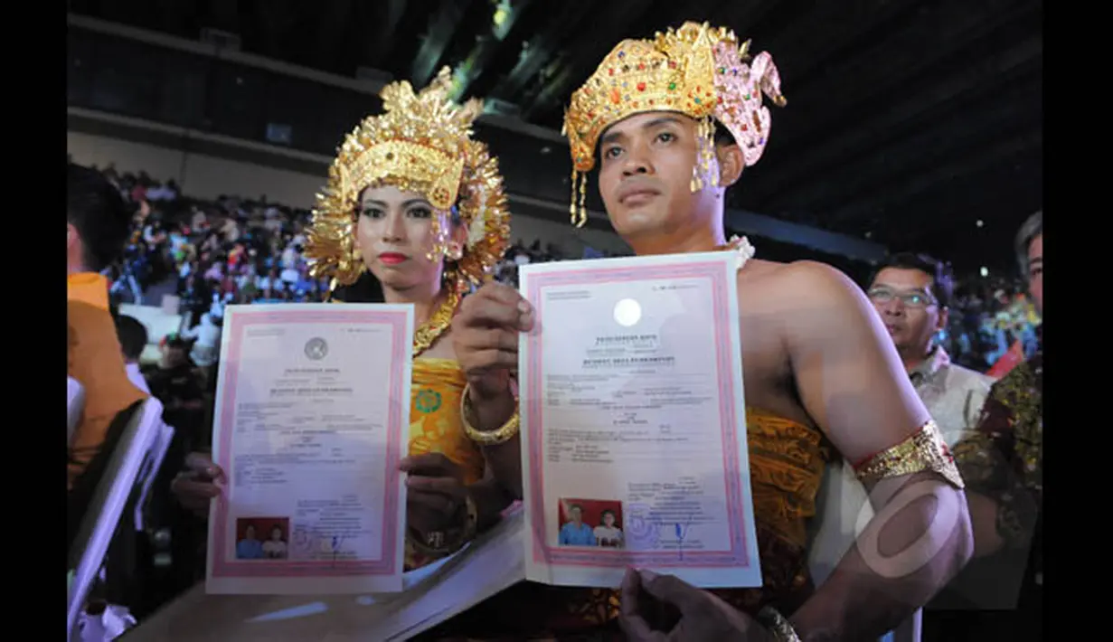Sepasang pengantin memperlihatkan surat nikah saat mengikuti Resepsi Penikahan Massal Pengantin se-Jabodetabek di Istora Senayan, Jakarta, Rabu (28/1/2015). (Liputan6.com/Herman Zakharia)
