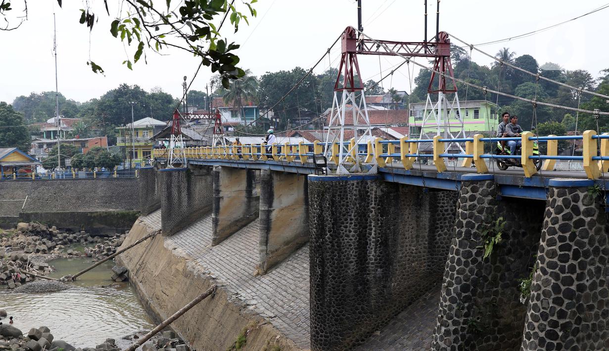 Warga berkendara motor melintasi Bendung Katulampa, Kota Bogor, Jawa Barat, Senin (3/8/2020). Debit air sungai Ciliwung di Bendung Katulampa mengalami penyusutan sejak satu bulan terakhir memasuki awal musim kemarau dengan ketinggan air 0 cm. (Liputan6.com/Helmi Fithriansyah)