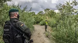 Petugas polisi Kolombia berjaga di "trochas" - jalur ilegal di perbatasan antara Kolombia dan Venezuela,  dekat jembatan internasional Simon Bolivar, di Cucuta, Kolombia (14/10/2020). (AFP/Schneyder Mendoza)