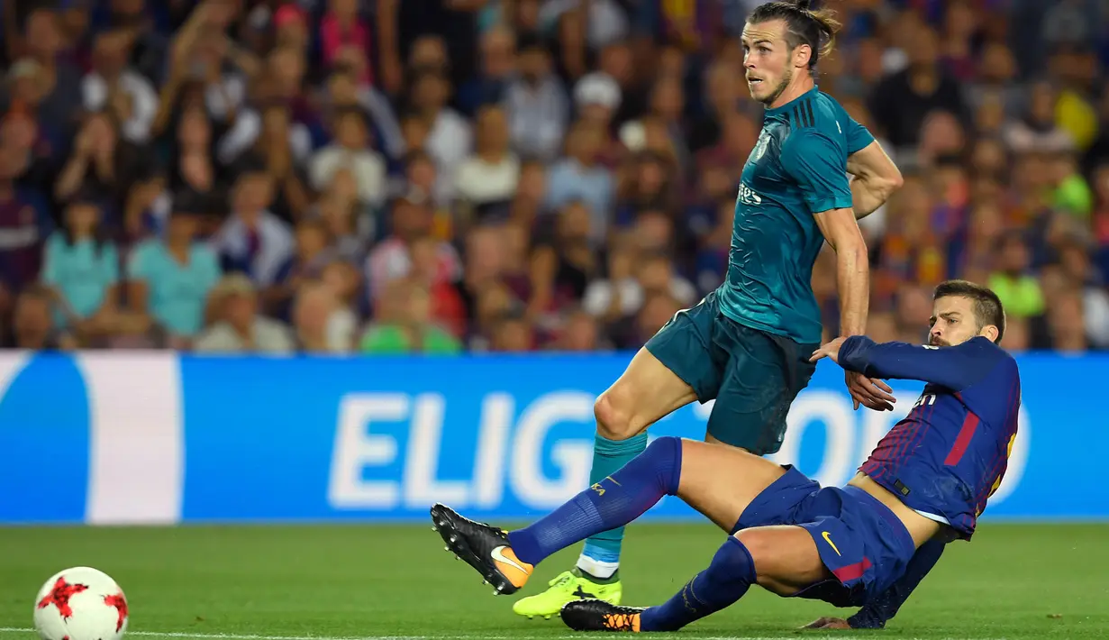 Pemain Real Madrid, Gareth Bale (kiri) menerima kartu kuning pada menit ke-41 saat melawan Barcelona dalam Piala Super Spanyol 2017 di Camp Nou stadium,Barcelona, (13/8/2017). Real Madrid menang 3-1. (AFP/Lluis Gene)