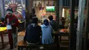Sejumlah warga menonton bersama di warung kopi saat Timnas Indonesia berhadapan dengan Australia pada babak 16 besar Piala Asia di kawasan Pinang, Tangerang, Minggu (28/1/2024). (Bola.com/M Iqbal Ichsan)