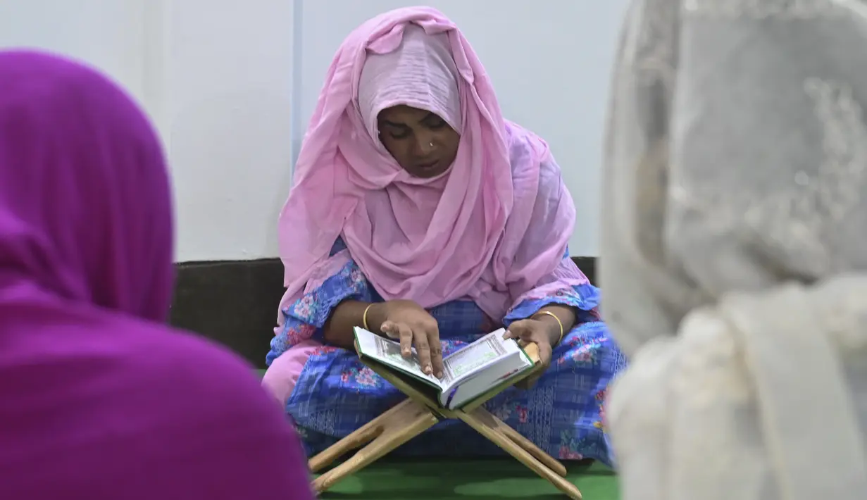 Anggota komunitas transgender belajar membaca Alquran di dalam Madrasah Dawatul Islam Tritio Linger untuk jenis kelamin ketiga, di Dhaka, Bangladesh, Selasa (17/11/2020). Ibu kota Bangladesh, Dhaka membuka madrasah pertama untuk transgender muslim pada 6 November 2020 lalu. (Munir Uz zaman/AFP)