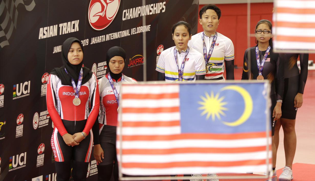 Pesepeda Indonesia, Ni'mal Magfiroh dan Sri Sugiyanti, mengikuti seremoni medali nomor 3000 meter persuit individu B saat Asian Track Championship 2019 di Veledrome, Jakarta, Jumat (11/1). Pasangan ini berhasil meraih perak. (Bola.com/Yoppy Renato)