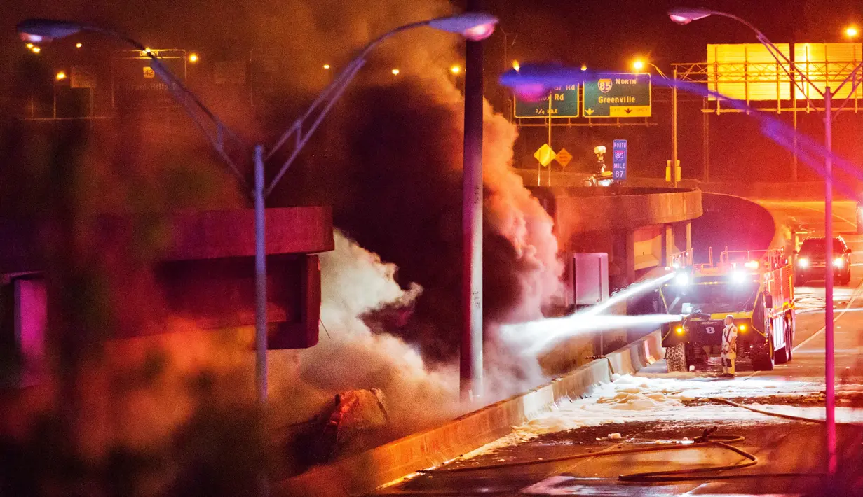 Kepulan asap terlihat dari kebakaran jembatan layang di jalur Interstate 85, Atlanta, AS, Kamis (30/3). Pihak berwajib memastikan tidak ada korban, kendati insiden itu memperparah kemacetan di ruas yang sangat padat itu. (AP Photo/David Goldman)