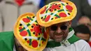 Penggemar Italia yang mengenakan topi pizza menunggu kick off di tengah kerumunan menjelang pertandingan sepak bola Euro 2024 Grup B antara Spanyol dan Italia di Arena AufSchalke, Gelsenkirchen pada 20 Juni 2024. (Alberto PIZZOLI/AFP)