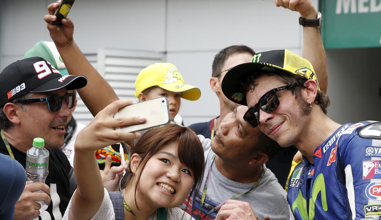 Valentino Rossi berfoto bersama penggemarnya setelah latihan bebas GP Malaysia di Sirkuit Sepang, Malaysia, (23/10/2015). (Reuters/Olivia Harris)