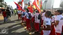 Sejumlah remaja membawa bendera negara-negara peserta Sea Games di Jakarta, Minggu (30/4). Kirab itu berlangsung guna menyambut Sea Games Kuala Lumpur 2017. (Liputan6.com/Johan Tallo)