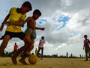 Anak-anak Rohingya bermain sepak bola di kamp pengungsi Kutupalong di Ukhia, Bangladesh, 19 Juli 2018. Piala Dunia 2018 mungkin sudah berakhir, namun demam pesta akbar sepak bola itu masih terasa di kamp pengungsi terbesar di dunia. (AFP/Munir UZ ZAMAN)