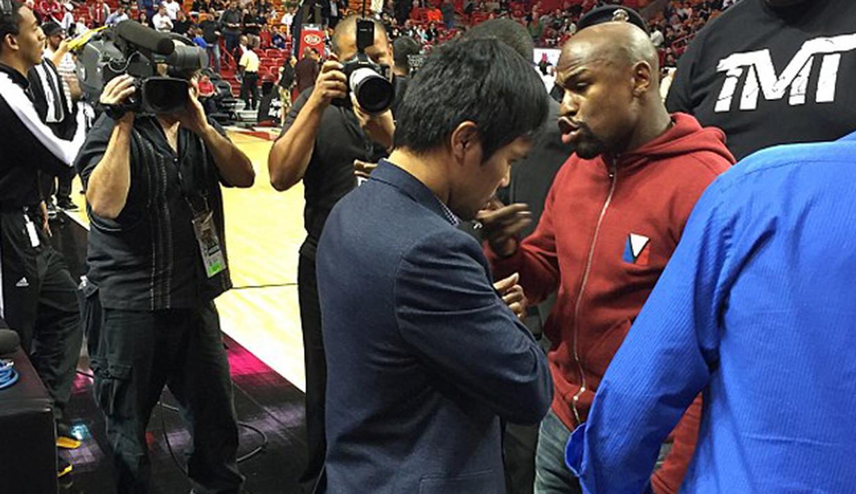 Floyd Mayweather Jr menghampiri Manny Pacquiao saat menyaksikan pertandingan NBA antara Miami Heat dan Milwaukee Bucks, AS, Rabu (28/1/2015). (Dailymail)