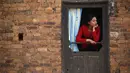 Seorang wanita menonton festival Swasthani Bratakatha, Nepal , (19/2). Kaum wanita diwajibkan berpuasa yang dipercaya mampu mensejahterakan keluarga mereka dan yang tidak memiliki pasangan akan mendapatkan jodoh yang baik. (REUTERS / Navesh Chitrakar)