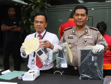 Kabid Humas Polda Metro Jaya Kombes Pol Argo Yuwono menunjukkan barang bukti di Polda Metro Jaya, Jakarta, Rabu (18/4). Subdit Cyber Crime Ditreskrimsus menangkap WNA Nigeria pelaku penipuan melalui Facebook dan WhatsApp. (Liputan6.com/Arya Manggala)