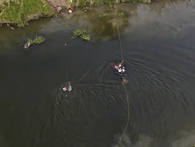 Imigran menyeberangi sungai Rio Grande ke Amerika Serikat dari Matamoros, Meksiko, Rabu, 10 Mei 2023. (AP Photo/Fernando Llano)