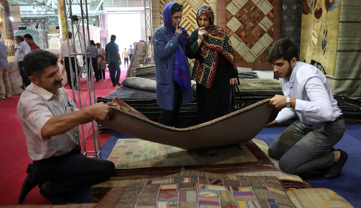 Pedagang memamerkan karpet tenun dagangannya kepada pengunjung pameran di Teheran, Iran, Kamis (29/8/2019). Pemberlakuan sanksi atas Iran oleh AS juga mempengaruhi pasar di Eropa dan negara-negara lain. (AP Photo/Vahid Salemi)