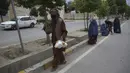 Warga membawa makanan berbuka puasa gratis yang disumbangkan oleh sukarelawan selama bulan puasa suci Ramadan di Kabul, Afghanistan, Kamis (7/5/2020). Muslim di seluruh dunia melewati Ramadan tahun ini di tengah pandemi virus corona COVID-19 dan PHK. (AP Photo/Rahmat Gul)