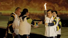 Wapres RI, Jusuf Kalla, menyerahkan api obor kepada pebulutangkis asal Yogyakarta, Kinarsih, saat prosesi kirab obor di Candi Prambanan, Rabu (18/7/2018). Api obor Asian Games tersebut akan dibawa mengelilingi 18 provinsi. (Bola.com/M Iqbal Ichsan)
