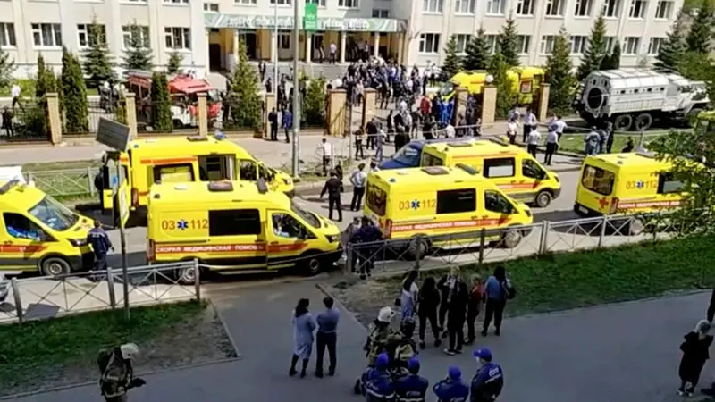 Ambulans dan truk polisi diparkir di sebuah sekolah setelah penembakan, di Kazan, Rusia, Selasa, 11 Mei 2021. Media Rusia melaporkan bahwa beberapa orang telah tewas dan terluka dalam penembakan di sekolah tersebut. (AP Photo)