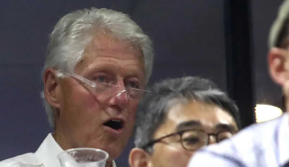 Ekspresi mantan presiden AS, Bill Clinton saat menonton pertandingan antara Roger Federer dan John Millman di AS Terbuka 2018, New York, Senin (3/9). (ALEX PANTLING/GETTY IMAGES NORTH AMERICA/AFP)